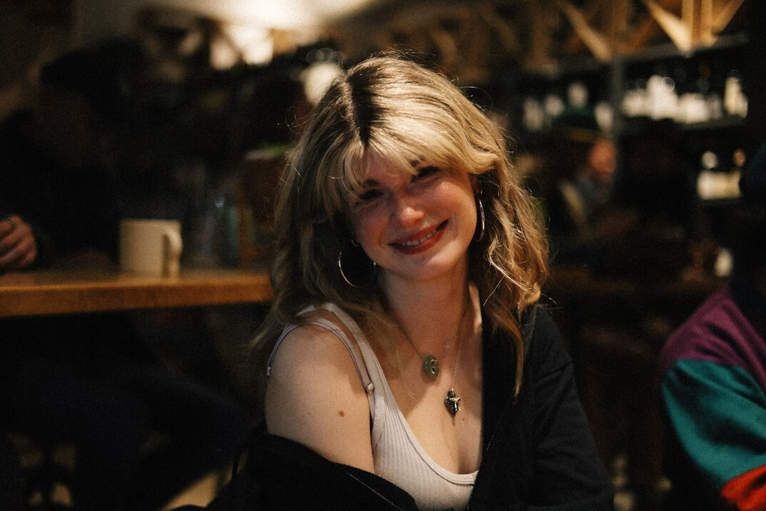 Portrait of a woman with light hair smiling at the camera